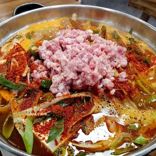 黄金豆田米其林页面的豆腐锅照片；红色汤底与肉末可见，具体菜名及现价未核实。