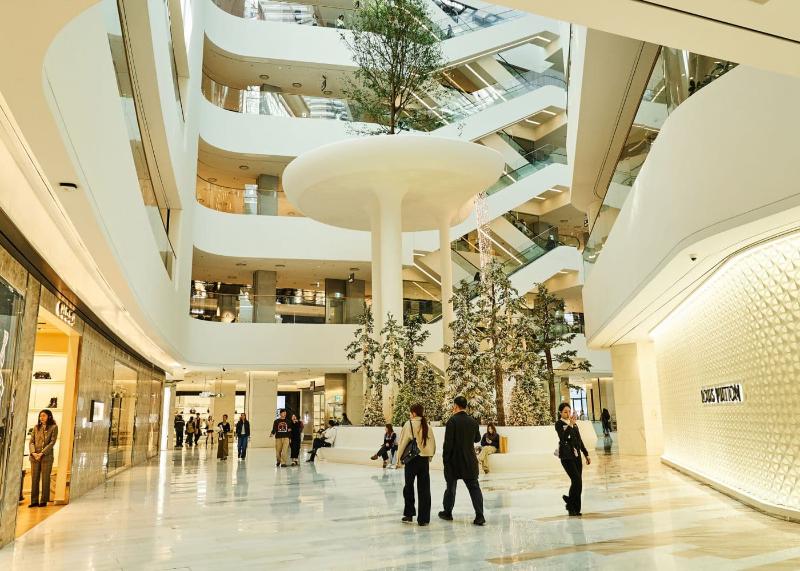 白色中庭与植物空间实景；现场临时布置与人流会变化。