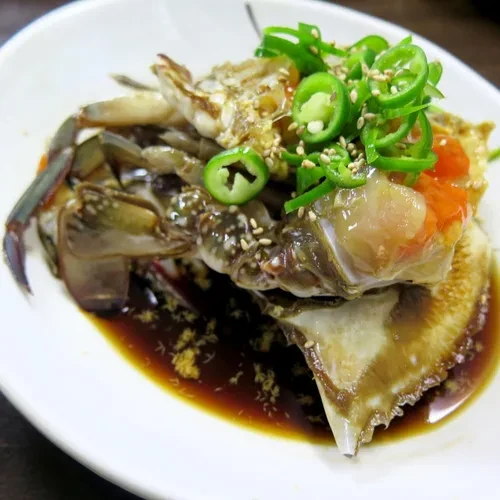 真味食堂指南页另一盘生蟹实拍；青辣椒等外观配料可见，辣度仍需问店方。