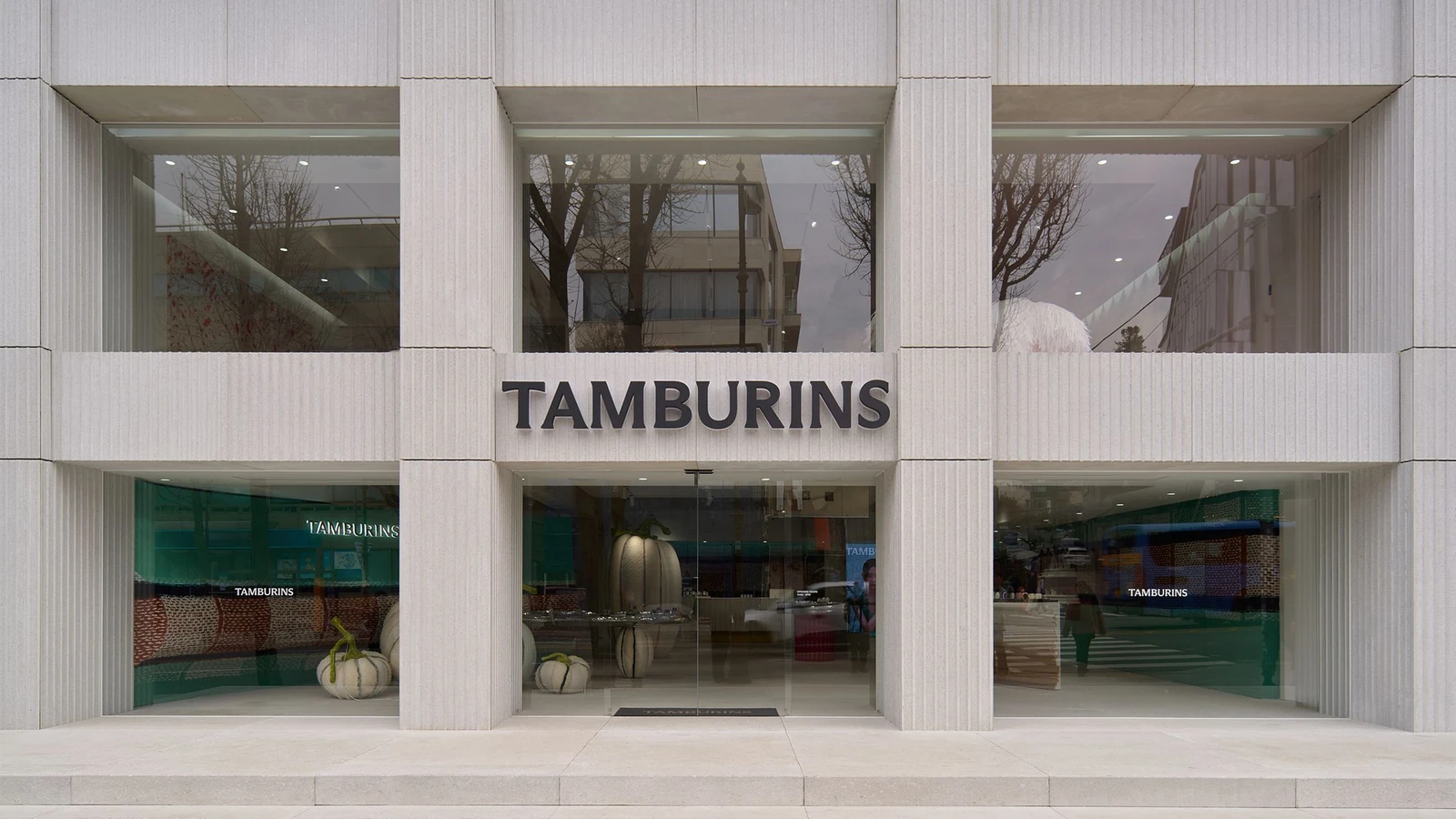 汉南店官方门头照片：浅色外墙、大玻璃窗与TAMBURINS字样。