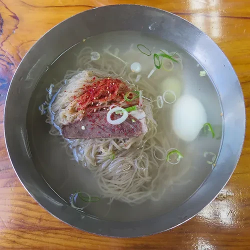 笔洞面屋指南页冷面，清汤、面团、肉片、葱与蛋可见；不据照片推定配方比例。