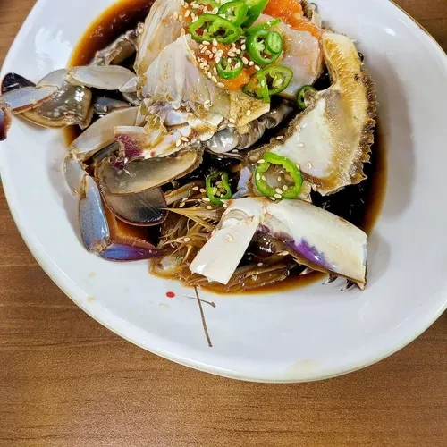 真味食堂指南页酱油生蟹照片，可见分切蟹身与酱汁；不能由照片保证当日蟹黄多少。