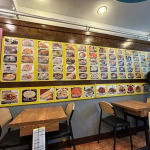 会贤店历史店内图：墙上图片菜单和小桌；2024年照片上的价格不作现价。